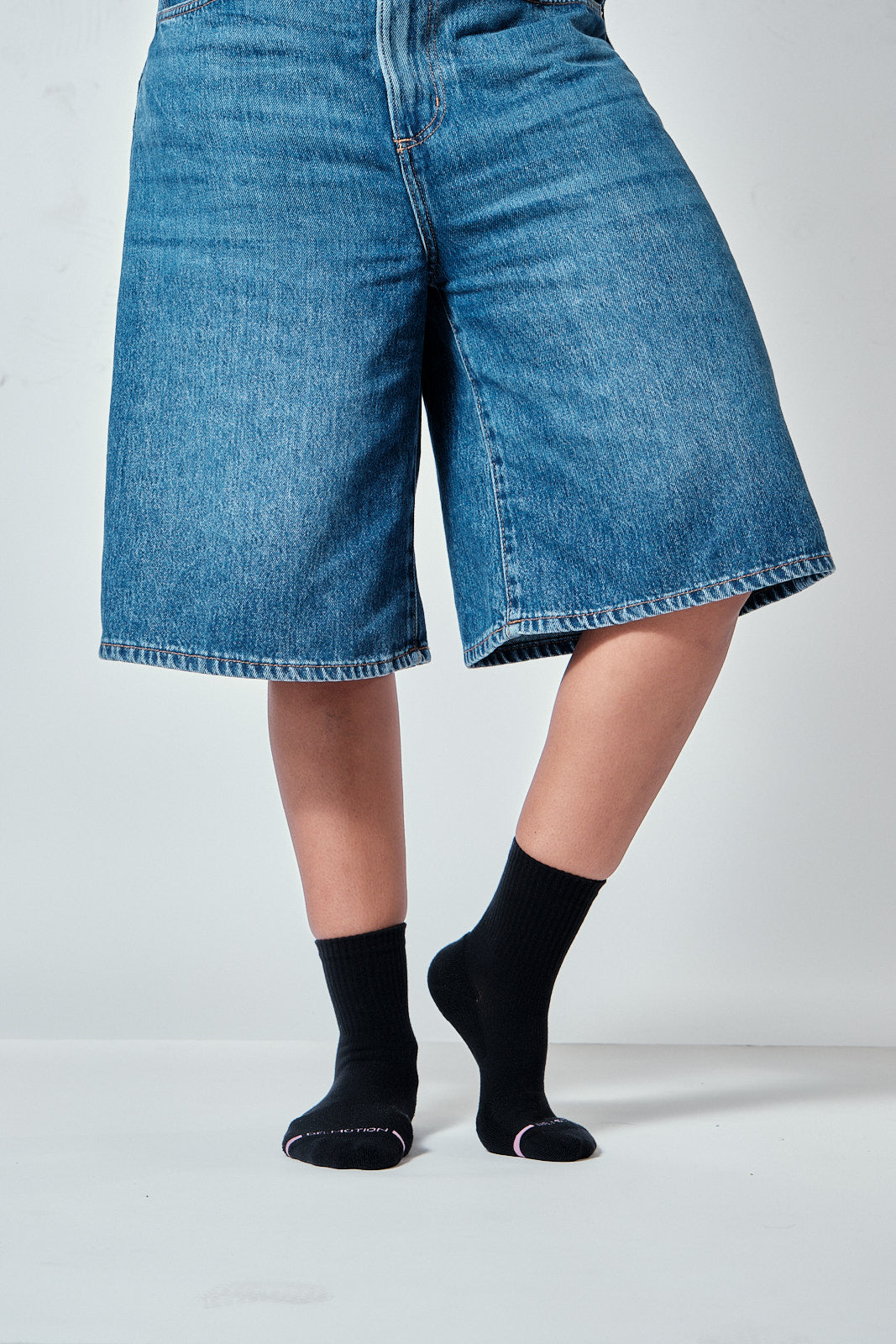 Black mid-crew compression socks worn in a lifestyle setting