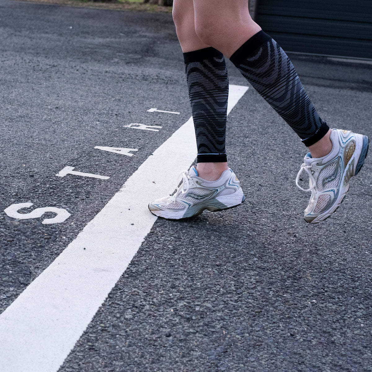 Black compression calf sleeves worn in a lifestyle setting