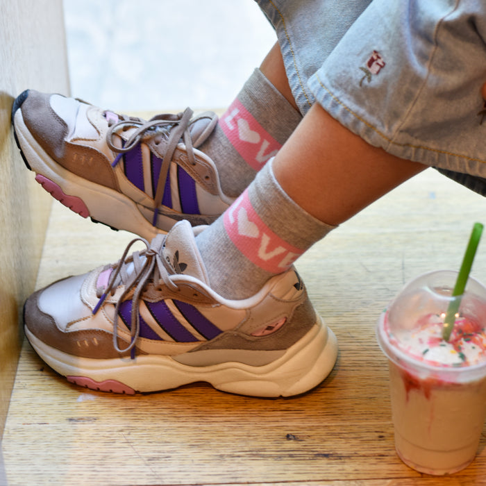 Light grey heather mid-crew compression socks worn in a lifestyle setting