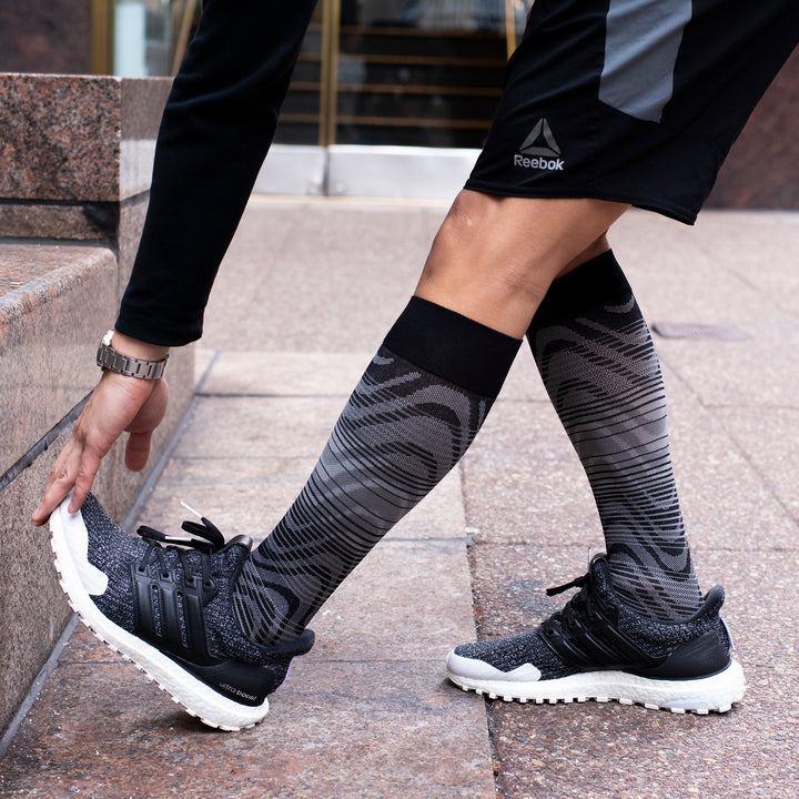 Man training in black sports compression knee-high socks